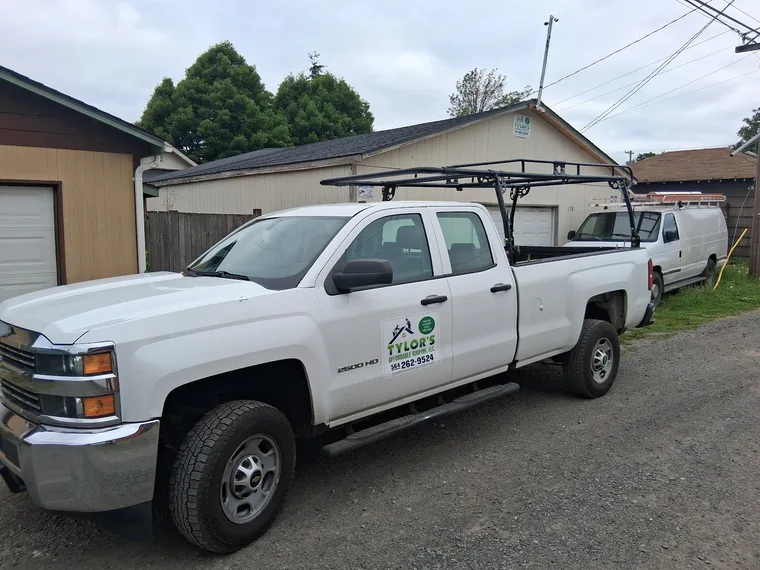 Tylor's Affordable Roofing lettered work truck with ladder rack