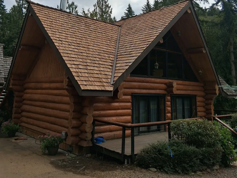 Log home with a brand-new cedar shake roof by Tylor's Affordable Roofing